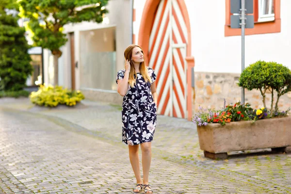 Krásná mladá žena s dlouhými vlasy v letních šatech jít na procházku v německém městě. Happy dívka těší procházky v roztomilé malé fachwerk město se starými domy v Německu. — Stock fotografie