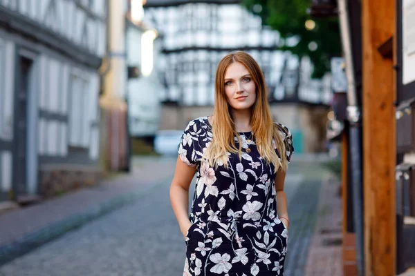 在德国城市散步的年轻漂亮的女人,穿着夏装,留着长发.在德国，快乐的女孩喜欢在有老房子的可爱小镇上散步. — 图库照片