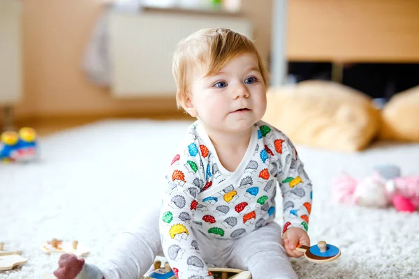 Hermosa linda niña hermosa jugando con juguetes educativos como rompecabezas de madera en casa o guardería. Feliz niño sano que se divierte con coloridos juguetes diferentes. Niño aprendiendo diferentes habilidades —  Fotos de Stock