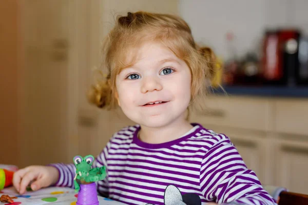 Adorable linda niña pequeña con arcilla colorida. Bebé saludable jugando y creando juguetes a partir de masa de juego. Moldeo de niños pequeños modelado de arcilla y aprendizaje — Foto de Stock