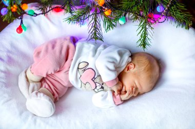 Bir hafta eski yeni doğan bebek arka plan üzerinde renkli garland ışıklı Noel ağacının yanında uyku. Sevimli çocuk, huzurlu rüya küçük bebek kız closeup. Aile, Xmas, doğum, yeni hayat