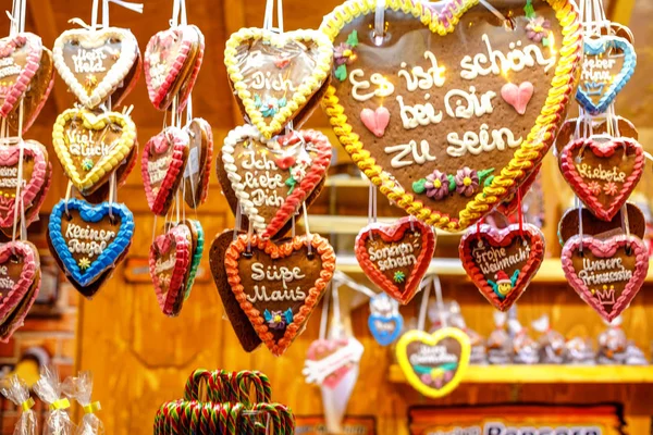 Pepparkakshjärtan på tyska julmarknad. Nürnberg, München, Fulda, Berlin, Hamburg Xmas marknaden i Tyskland. I tyska språket är det vackert att vara med dig. — Stockfoto
