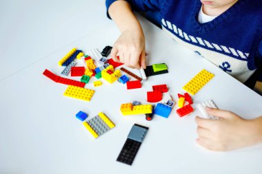 Renkli plastik bloklar çok oynayan çocuğun elleri closeup. Çocuk bina ve robot oluşturma ile eğleniyor. Yaratıcı eğlence modern teknik ve robotik.