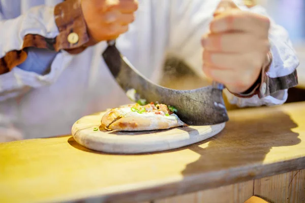 Traditional bread with sour cream and ham on German Christmas market. Closeup of fresh baked pretzel and hands of man on Xmas fair in Germany — Stock Photo, Image