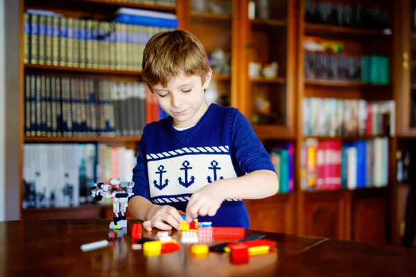 Lilla blonda barn leker med massor av färgglada plast block. Söt skol unge pojke ha kul med att bygga och skapa robot. Kreativ fritid modern Technic och Robotic. — Stockfoto