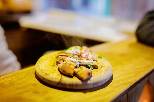 Traditioneel brood met zure room en ham op de Duitse kerstmarkt. Close-up van vers gebakken krakeling en handen van de mens op Xmas Fair in Duitsland — Stockfoto