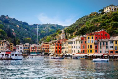 Portofino 'nun küçük limanında renkli evleri, lüks tekneleri ve yatları olan güzel küçük bir köyü var. Liguria, İtalya. Sıcak bir yaz gününde