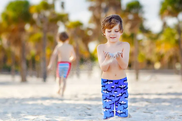 Two little kids boys having fun on tropical beach, happy best friends playing with sand, friendship concept. Siblings brothers in swim trousers. Key Biscayne, Miami, Florida — Stock Photo, Image