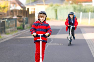 İki küçük çocuk okula giderken ya da dönerken scooter kullanıyor. 7 yıllık okul öğrencileri yağmur birikintisinin içinden geçiyor. Komik kardeşler ve en iyi arkadaşlar birlikte oynuyorlar. Okuldan sonra çocuklar