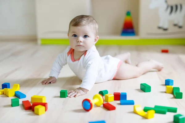 Schattige babymeisje spelen met kleurrijke rammelaar speelgoed — Stockfoto