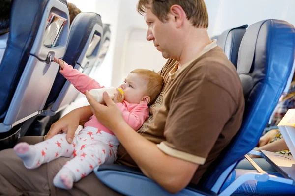 Отец держит свою маленькую дочь во время полета на самолете собирается в отпуск — стоковое фото