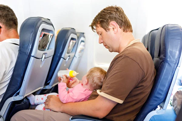 Vader zijn baby dochter houden tijdens de vlucht op het vliegtuig op vakantie te gaan — Stockfoto