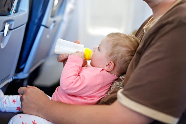Padre che tiene in braccio sua figlia durante il volo in aereo in vacanza — Foto Stock