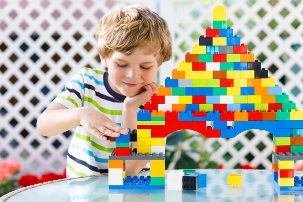 Niño rubio y niño jugando con un montón de bloques de plástico de colores. —  Fotos de Stock