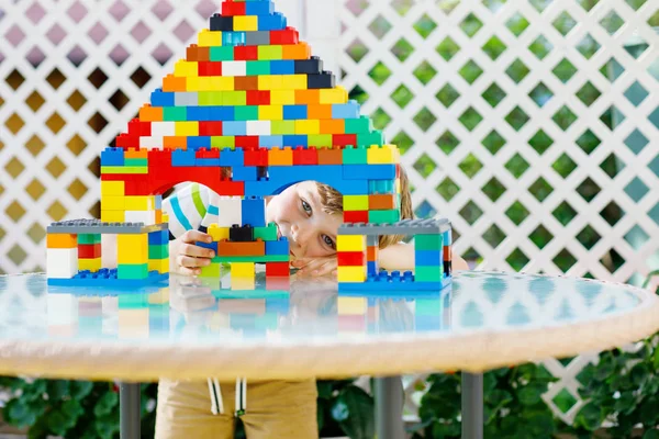 Küçük sarışın çocuk ve çocuk bir sürü renkli plastik blokla oynuyorlar.. — Stok fotoğraf