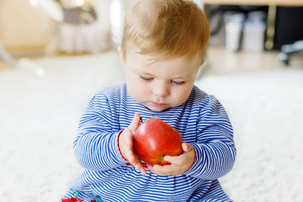 Little adorable baby girl eating big red apple — Stock Photo, Image