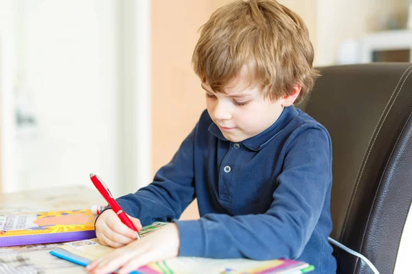 Menino pré-escolar em casa fazendo lição de casa escrevendo cartas com canetas coloridas — Fotografia de Stock