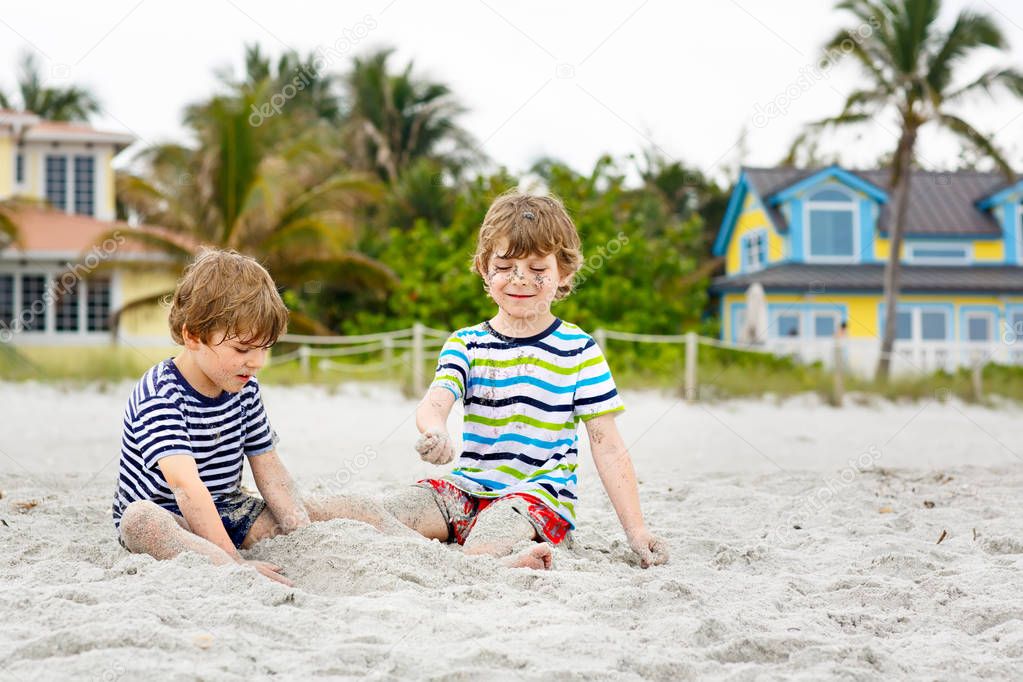 Two little kids boys having fun on tropical beach