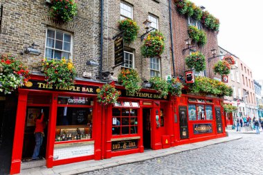 DUBLIN, IRELAND - 1 Temmuz 2019: Temple Bar Dublin kültürel bölgesinde her yıl binlerce turist tarafından ziyaret edilen ünlü bir simgedir. İrlanda başkentinin merkezindeki Tapınak Bar - erkek kadın