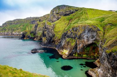 Carrick-a-Rede Rope Bridge, County Antrim Ballintoy yakınlarındaki ünlü halat köprü görünümü, İrlanda kıyı şeridi üzerinde Kuzey İrlanda. Turistik cazibe, bulutlu günde küçük adaya köprü.