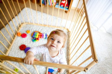 Oyun parkında duran güzel küçük kız. Sevimli sevimli çocuk renkli oyuncaklarla oynuyor. Ev ya da kreş, çocuklar için güvenli. Yalnız bebek annesini bekliyor.