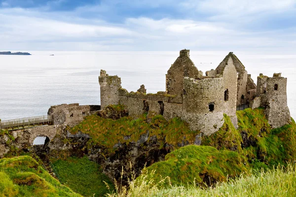 Ruinerna av Dunluce Castle, Antrim, Nordirland under soliga dagar med halv molnigt himmel. — Stockfoto