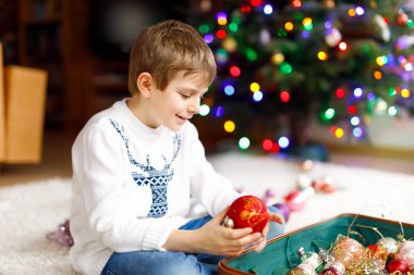Güzel çocuk ve renkli eski yılbaşı oyuncakları ve topları. Çocuk Noel ağacı süslemesi