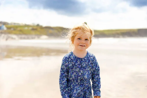 Pequeña niña linda en la playa de surfistas Ballybunion, divirtiéndose en la tabla de surf por primera vez, costa oeste de Irlanda —  Fotos de Stock