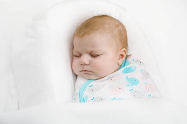 Uyuyan sevimli küçük yeni doğan bebek kız battaniyeye sarılmış