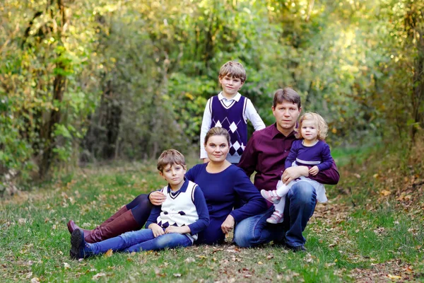 Портрет молодих батьків з трьома дітьми. Мати, батько, двоє дітей брати хлопчики і маленька мила дівчинка-сестричка розважаються разом в осінньому лісі. Щаслива сім'я з п'яти — стокове фото