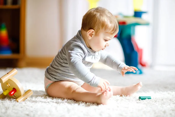 Adorable niña jugando con juguetes educativos. Feliz niño sano que se divierte con colorido juguete de madera diferente en casa. Desarrollo temprano para niños con juguete natural. — Foto de Stock