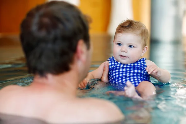 Happy middle-aged father swimming with cute adorable baby girl in swimming pool. — Stock Photo, Image