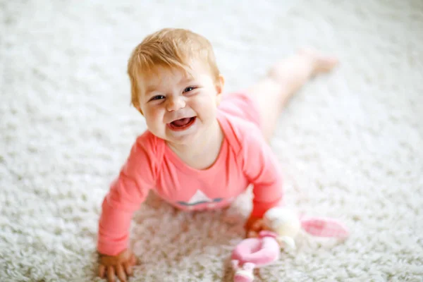 Niña linda aprendiendo a gatear. Niño sano arrastrándose en la habitación de los niños con juguetes de colores. Vista trasera de las piernas del bebé. Lindo niño descubriendo el hogar y aprendiendo diferentes habilidades —  Fotos de Stock