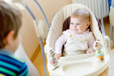 Yeni doğan bebek kız, sevimli kız kardeşi olan mutlu küçük çocuk çocuk. Kardeşler. Kardeşim ve renkli oyuncaklar ve çıngıraklar ile birlikte oynayan bebek. Bağ çocuklar. İki bağ, aşk, Aile..