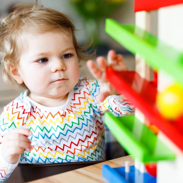 Entzückend süße schöne kleine Mädchen spielen mit Lernspielzeug zu Hause oder im Kinderzimmer. fröhliches gesundes Kind, das Spaß an der bunten Kugelbahn aus Holz hat. Kind lernt Ball zu halten und zu rollen. — Stockfoto