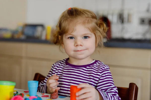 Förtjusande söt liten småbarn flicka med färgglada lera. Friska barn spelar och skapa leksaker från lekdeg. Små barn formning modellera lera och lärande — Stockfoto