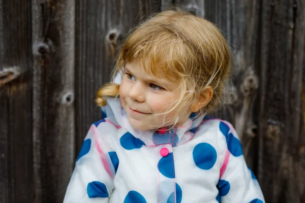 Retrato ao ar livre da menina sorrindo feliz pequena criança vestindo jaqueta de chuva no dia nublado chuvoso. Criança saudável bonito em roupas coloridas atividade ao ar livre — Fotografia de Stock