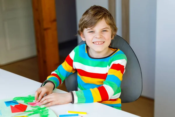 Ragazzino che fa fiori di tulipano origami di carta per una cartolina per la festa della mamma o il compleanno. Carino bambino della scuola elementare facendo artigianato — Foto Stock