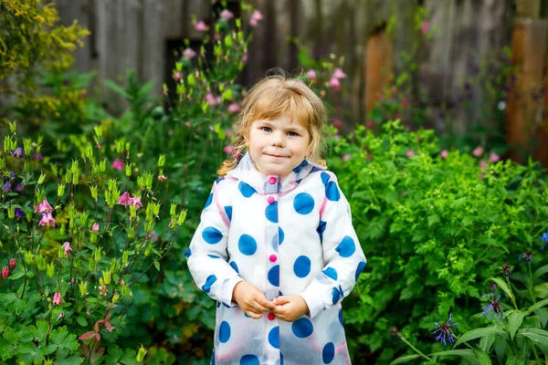 Retrato al aire libre de la pequeña niña sonriente feliz con chaqueta de lluvia en el día nublado lluvioso. Lindo niño sano en ropa colorida actividad al aire libre —  Fotos de Stock