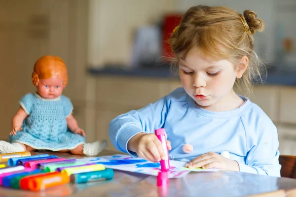 Lite ensam småbarn flicka målning med filtpennor under pandemisk coronavirus karantän sjukdom. Glad kreativt barn med gammal vintage docka, hemundervisning och dagis hemma med föräldrar — Stockfoto