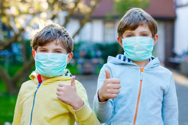 Dos niños con máscara médica como protección contra la enfermedad por coronavirus pandémica. Niños, hermanos encantadores y mejores amigos usando equipo de protección como lucha contra covid 19. — Foto de Stock