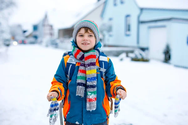 学校に行く途中で雪を楽しんでいる幸せな子供の男の子 — ストック写真