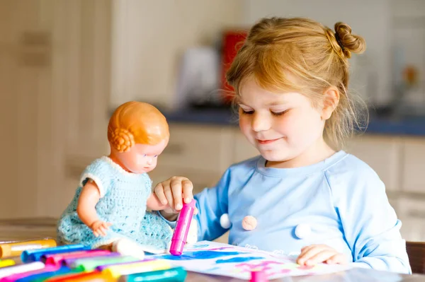 在大流行的验尸检疫病中，一个小孩带着毛笔作画。带着老式玩具娃娃的富有创造力的快乐孩子，和父母一起在家学习和照顾孩子 — 图库照片