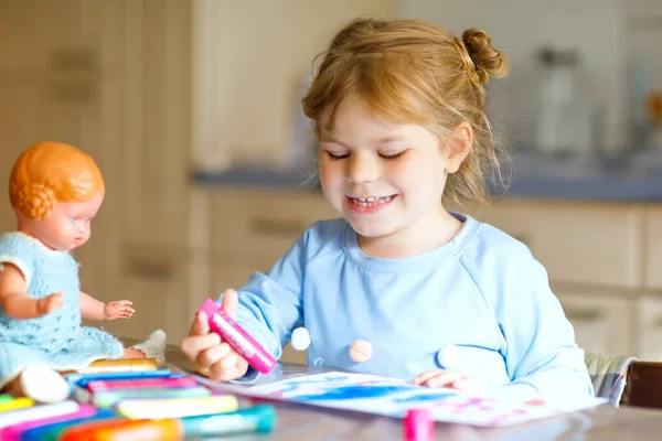 Poco solo niña pintando con plumas de fieltro durante la enfermedad pandémica de cuarentena coronavirus. Feliz niño creativo con la vieja muñeca vintage, educación en casa y guardería en casa con los padres — Foto de Stock