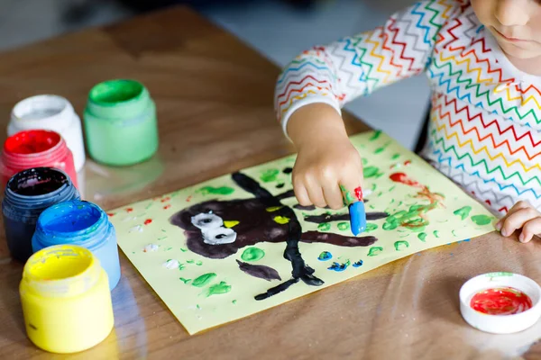 Primer plano de la pequeña niña creativa pintando con los colores de los dedos un pájaro búho. El niño se divierte dibujando en casa, en el jardín de infantes o en la guardería preescolar. Juegos, educación y aprendizaje a distancia para — Foto de Stock