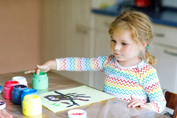 Μικρή δημιουργική κοριτσάκι ζωγραφική με τα χρώματα των δαχτύλων ένα πουλί κουκουβάγια. Ενεργό παιδί που διασκεδάζει με τη ζωγραφική στο σπίτι, σε kindergaten ή νηπιαγωγείο. Παιχνίδια, εκπαίδευση και εξ αποστάσεως εκπαίδευση για τα παιδιά — Φωτογραφία Αρχείου