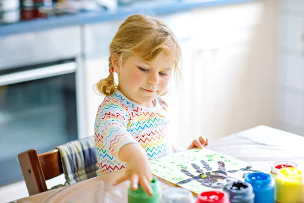 Little creative toddler girl painting with finger colors an owl bird. Active child having fun with drawing at home, in kindergaten or preschool. Games, education and distance learning for kids — Stock Photo, Image