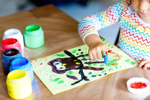 Closeup of little creative toddler girl painting with finger colors an owl bird. Child having fun with drawing at home, in kindergaten or preschool. Games, education and distance learning for kids. — Stock Photo, Image