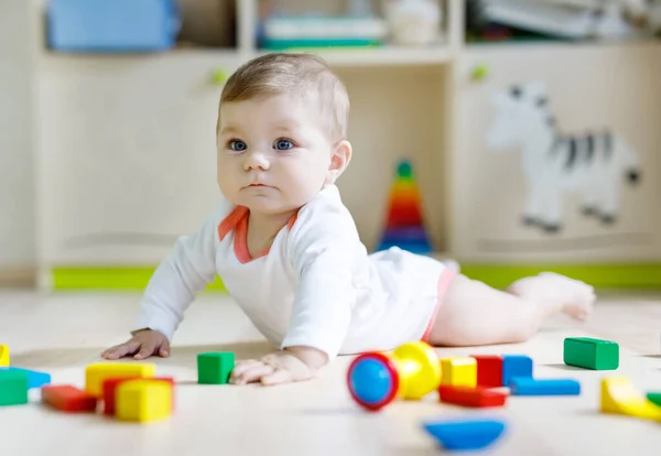 Schattige babymeisje spelen met kleurrijke rammelaar speelgoed — Stockfoto