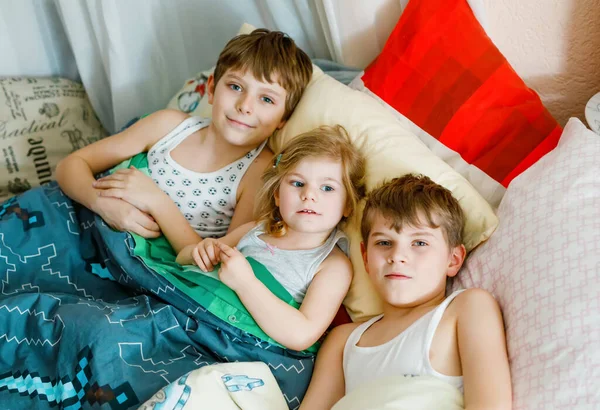 Three little kids on quarantine against coronovirus playing together at home. Two school boys and toddler girl having fun indoors. Active children. Stay at home concept. — Stock Photo, Image